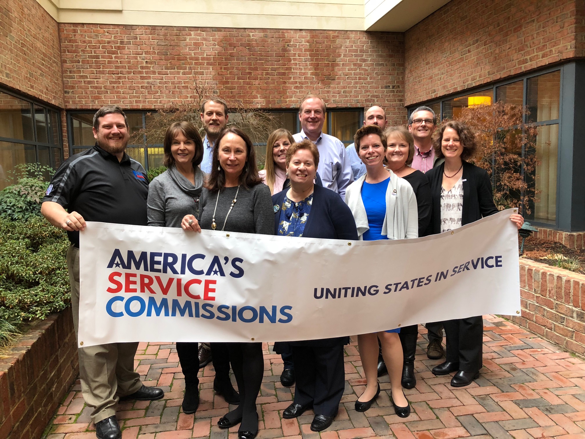 decorative. photo of ASC board and CEO with large ASC banner