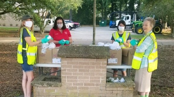 photo of four volunteers serving meals outside