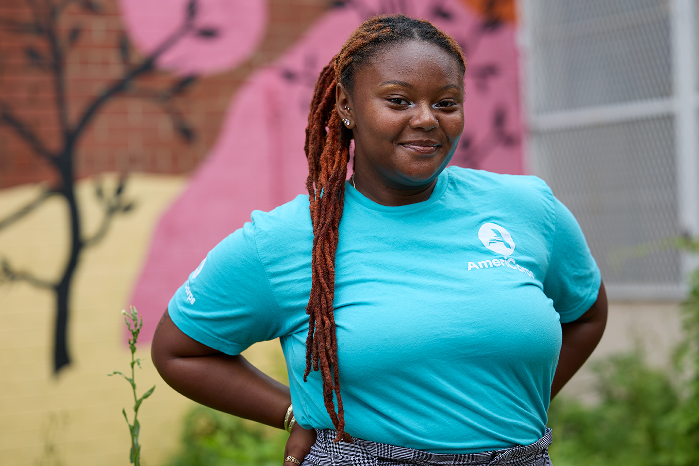 person smiling at camera wearing AmeriCorps logo tshirt